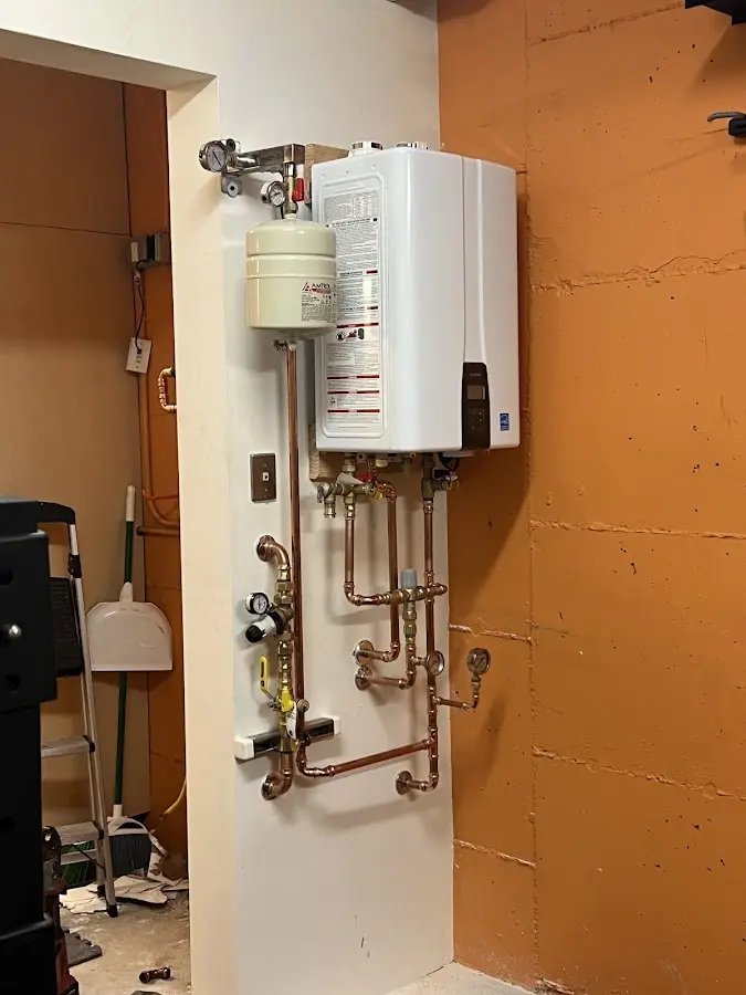Plumbing technician inspecting water heater connections in Durant